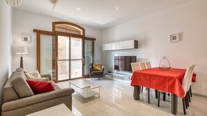 Un salon moderne comprenant un canapé, une table basse et un coin repas avec une table et des chaises.