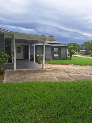 A residential house with a covered porch, a front door, and a garage. - Charming Studio apartment with AC, WiFi in delightful Orlando (Orlando)