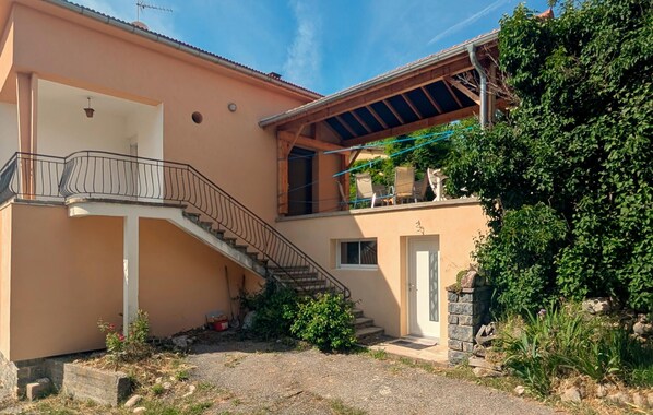 Un edificio de dos plantas con una escalera que conduce a un balcón.