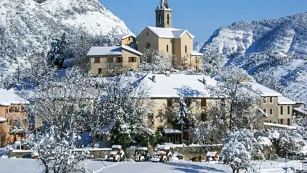 A snow-covered village with a prominent church on a hill, surrounded by residential buildings and trees. - 3 bedroom stunning home in Bellaffaire (Bellaffaire)