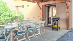 An outdoor patio with a table and chairs, a grill, and a gas cylinder. - 3 bedroom stunning home in Bellaffaire (Bellaffaire)