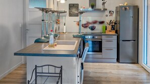 A modern kitchen with a central island, stainless steel appliances, and a view to the outside. - 3 bedroom stunning home in Bellaffaire (Bellaffaire)