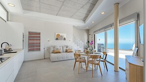 Una cocina moderna con comedor, sofá y un amplio ventanal con vistas.