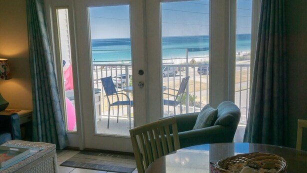 A room with a glass door leading to a balcony with a view of the beach and ocean. - Summerspell 303 (Miramar Beach)