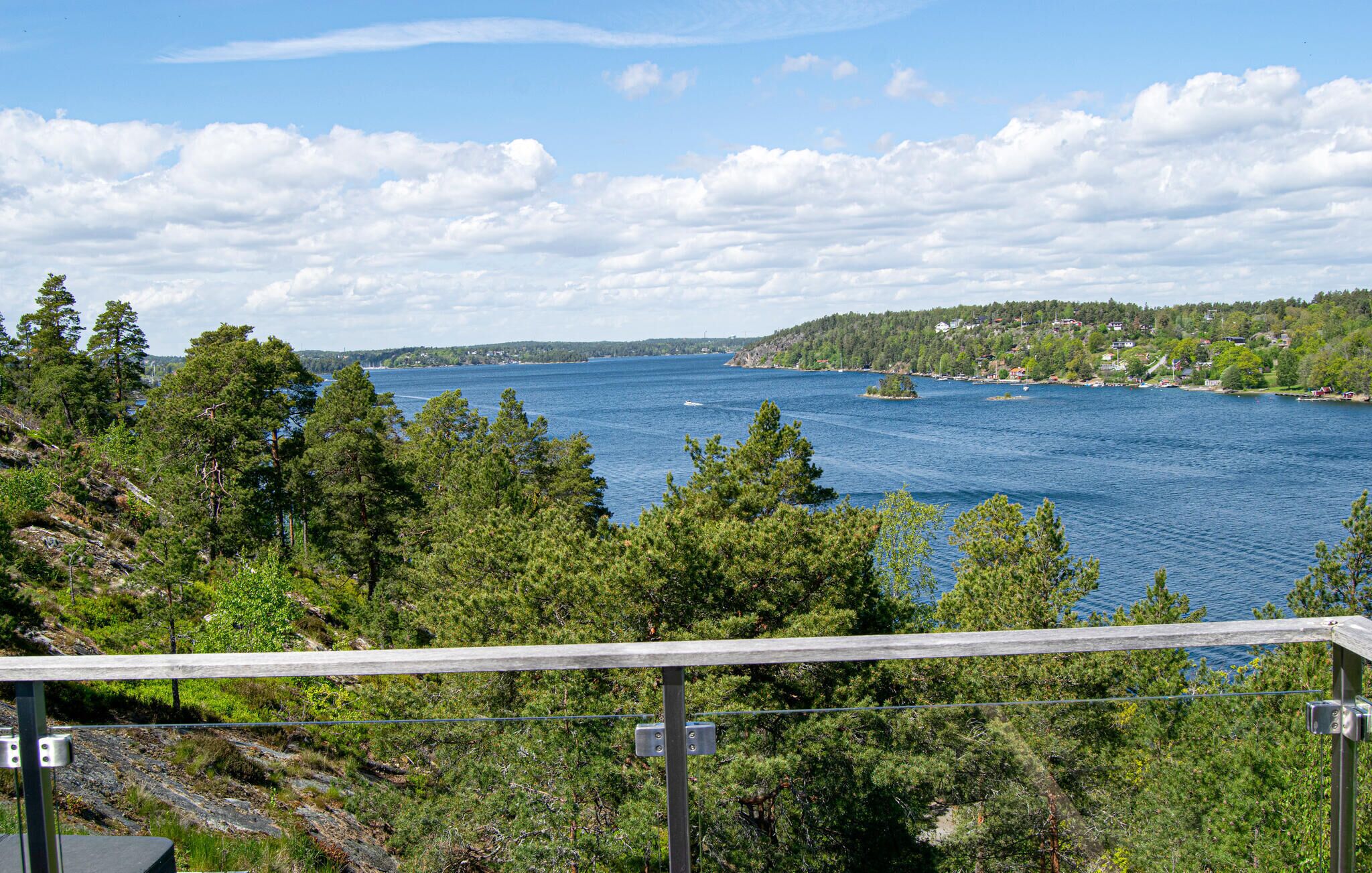 A scenic view of a lake with a forested shoreline and a distant town.
