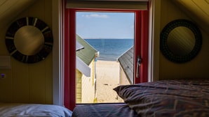 Une chambre avec vue sur la plage, accessible par une porte.