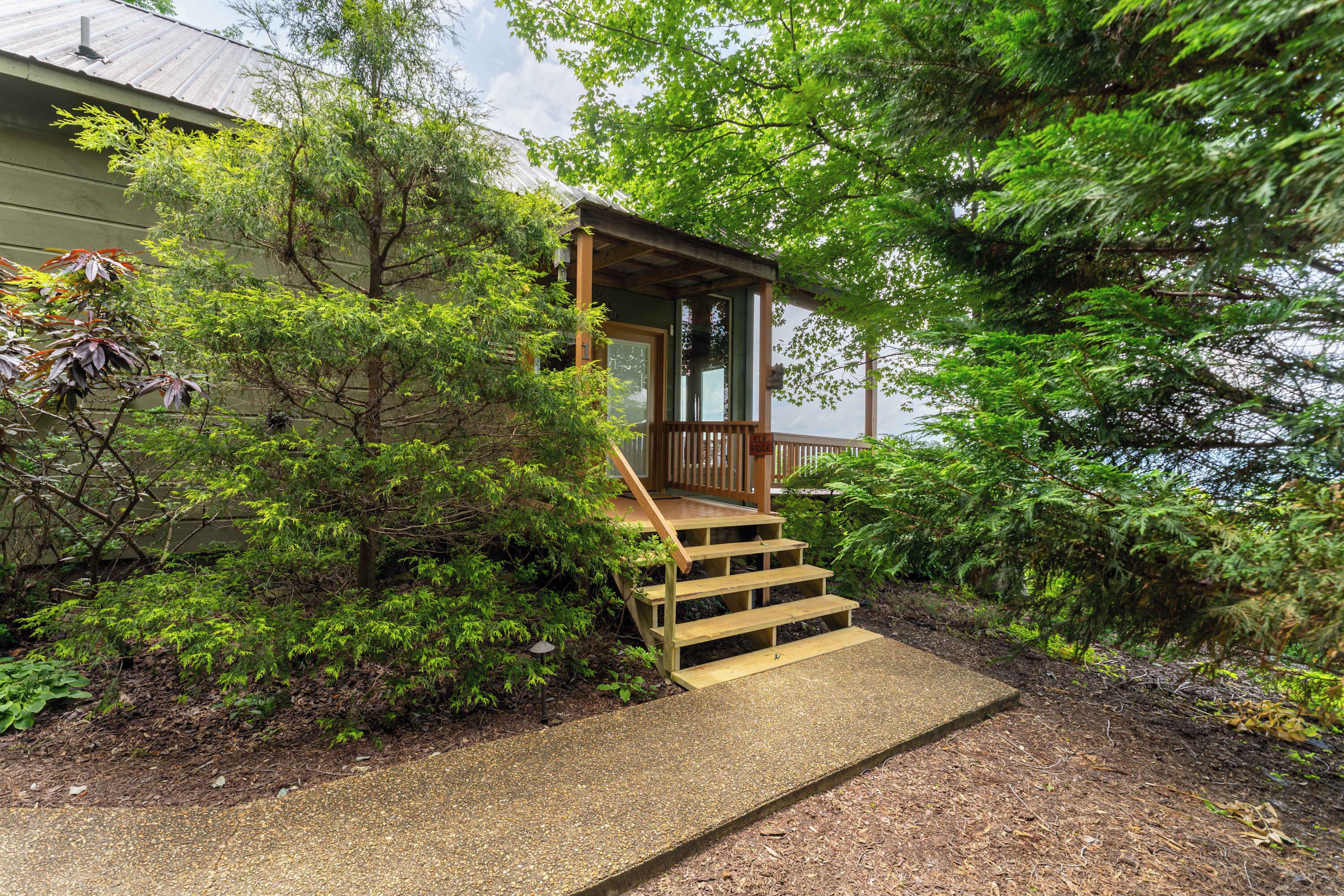 A wooden staircase leading to a covered porch with a view of a body of water.