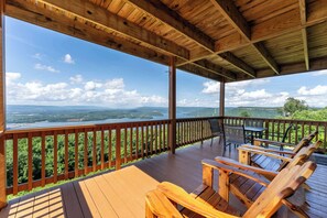 A wooden deck with a view of a lake and mountains.