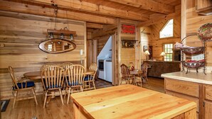A wooden interior with a dining area, a kitchen, and a living space. - The Cabins at Seven Foxes (Lake Toxaway)
