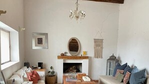 Una sala de estar acogedora con chimenea, un sofá, una mesa de centro y un sillón.