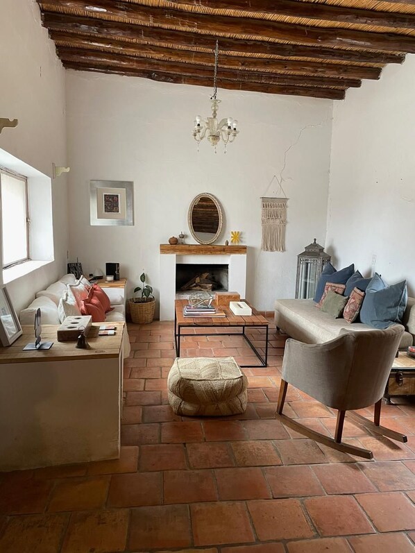 Una sala de estar acogedora con chimenea, un sofá, una mesa de centro y un sillón.