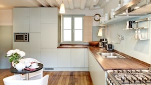 Una cocina moderna con encimera de madera, electrodomésticos de acero inoxidable y ventana con vistas.