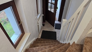 A staircase with a textured carpet, white walls, and a window. - Vacation Apartment (GF) at Grossensee - Relaxation Close to Hamburg (großensee)