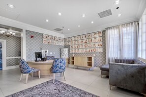 A spacious living area with a fireplace, a reception desk, and a large window with curtains. - Victorian Unit with Pool Access, Fireplace & Free Breakfast in SF SoMa (San Francisco)