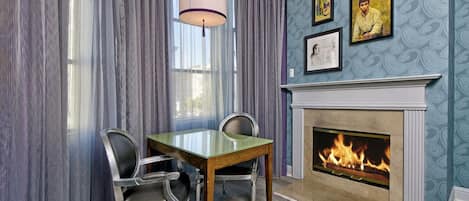 A dining area with a fireplace, a table, and chairs.