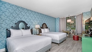 Une chambre d’hôtel avec deux lits, un bureau, une chaise, un miroir et une fenêtre avec des rideaux.