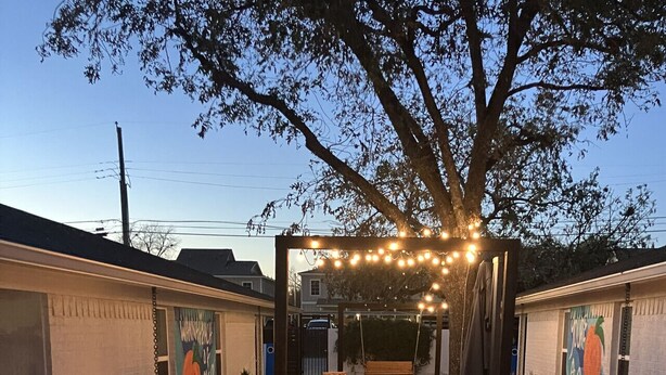 A backyard with a hot tub, outdoor seating, string lights, and a fire pit. - Uptown Peach ~Best 4 Baylor games/visits ~Sleeps 5 (Waco)