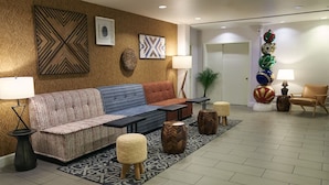 A modern lobby with a sofa, ottomans, and a coffee table. There are wall art pieces and a decorative plant. - 2 Stylish Units with Heated Rooftop Pools, Walk to SF Attractions (San Francisco)