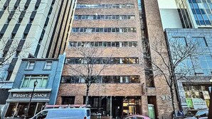 Un edificio de varios pisos con fachada de ladrillo y ventanas grandes.