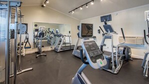 A gym with treadmills, elliptical machines, and weight equipment.