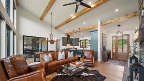 A spacious living room with leather furniture, a glass coffee table, and a cowhide rug. - Sky's the Limit - community pool, gym, hiking trails! (Boone)
