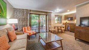 A hotel room with a sofa, armchair, coffee table, dining table, chairs, kitchen area, and a TV. - Peaceful Unit with Outdoor Pool, Free Breakfast & Free Parking (Palo Alto)