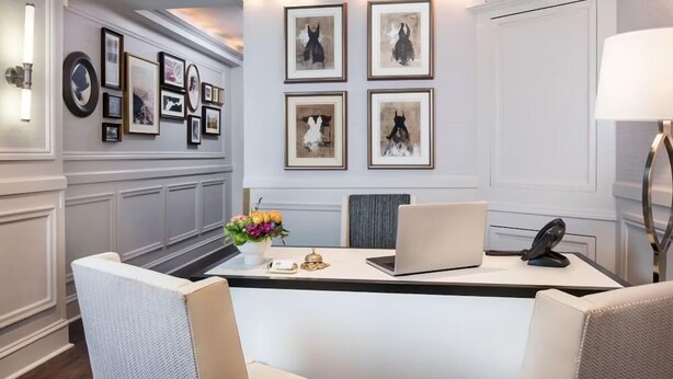 A modern office space with a reception desk, framed artwork, and a laptop. - Beautiful Boutique Room with Breakfast, Near Fisherman’s Wharf & Golden Gate (San Francisco)