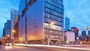 A modern hotel with a unique architectural design, featuring a prominent geometric facade and multiple floors with large windows.
