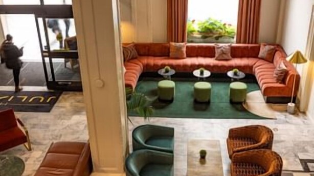 A modern lounge area with a sectional sofa, green ottomans, and wicker chairs. - 2 King Room in San Francisco’s Nob Hill, Near Union Square & Attractions (San Francisco)