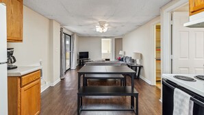 A modern kitchen with a dining table, wooden cabinets, and a ceiling fan.