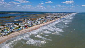 A coastal town with beachfront properties, a sandy beach, and a view of the ocean.