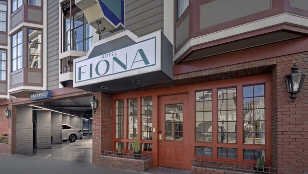 A hotel entrance with a prominent sign, a covered parking area, and a brick facade. - Victorian Charm, Rooftop Pool Access, Walk to Civic Attractions (San Francisco)