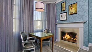 A dining area with a fireplace, a table, and chairs. - Free Breakfast Room, Heated Rooftop Pool Access Near AT&T Park (San Francisco)