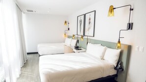 A hotel room with a large bed, two bedside tables, and a wall-mounted lamp. - Pet-Friendly Hotel Near Hollywood Sign & Rooftop Pool Access (Los Angeles)