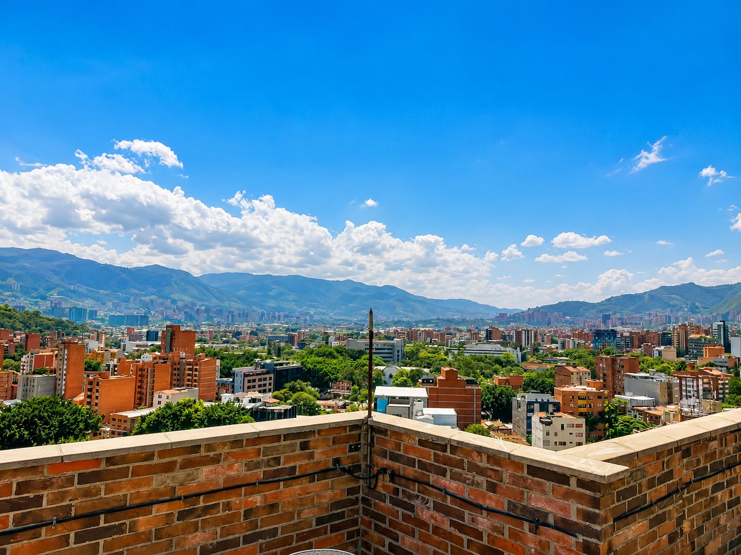 A cityscape with a clear sky and mountains in the background.