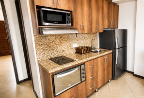 A compact kitchen with a microwave, a built-in oven, a sink, and a refrigerator. - Penthouse Rooftop  Gem in the Laureles (Medellín)