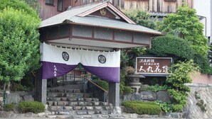 A traditional Japanese building with a stone staircase leading to a wooden entrance. - Hitomarukadan (Akashi)