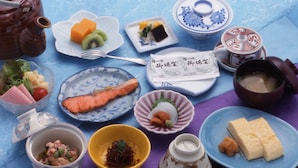 A variety of dishes and utensils on a table, including a teapot, bowls, plates, and a fork. - Hitomarukadan (Akashi)