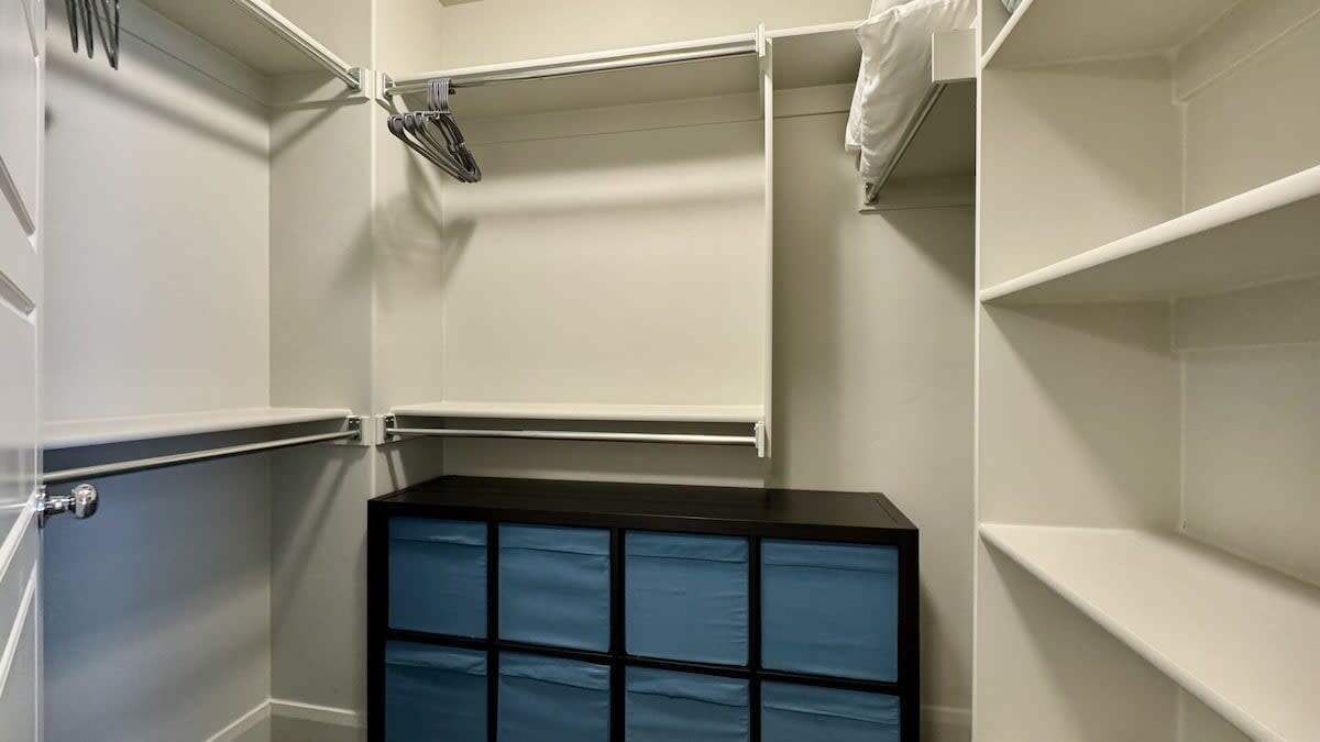 A storage closet with shelves and a blue storage unit.