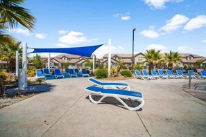 A poolside area with sun loungers and a blue shade sail. - Resort-Style | By Zion & St George | #1911 (Washington)