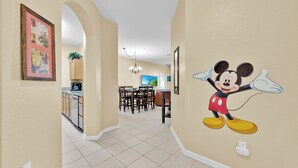 Un interno domestico con un murale di Topolino, un'area pranzo e una cucina.
