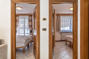 Una habitación con dos camas, un radiador y una ventana con cortinas.