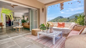 A spacious living area with a sofa, coffee table, and potted plants.