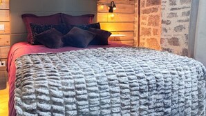 Ein Bett mit Kopfteil, mehreren Kissen und einer Decke.