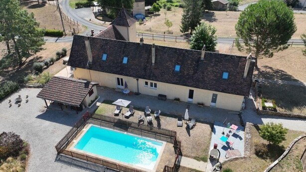 Un edificio con piscina, area salotto all'aperto e recinzione.