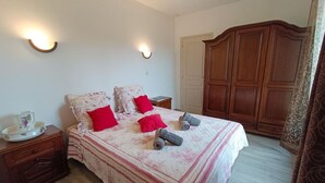 Una camera da letto con un letto, due comodini, un armadio e un tavolino.