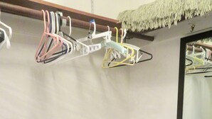 A room with a wall-mounted drying rack and a mirror reflecting the rack.