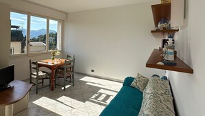 A living room with a sofa, a dining table, and a TV. - Splendido da aMare (Zoagli)
