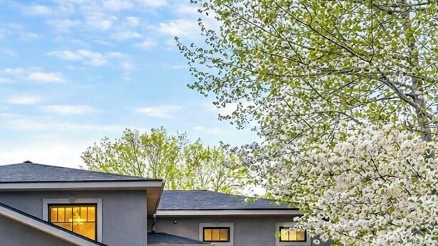 A modern two-story house with a garage, large windows, and a well-maintained garden with flowers and a tree. - 4 BR-7 Bed-Durango Dream House-Incredible Mountain/Golf Views w/ Chef’s Kitchen (Durango)