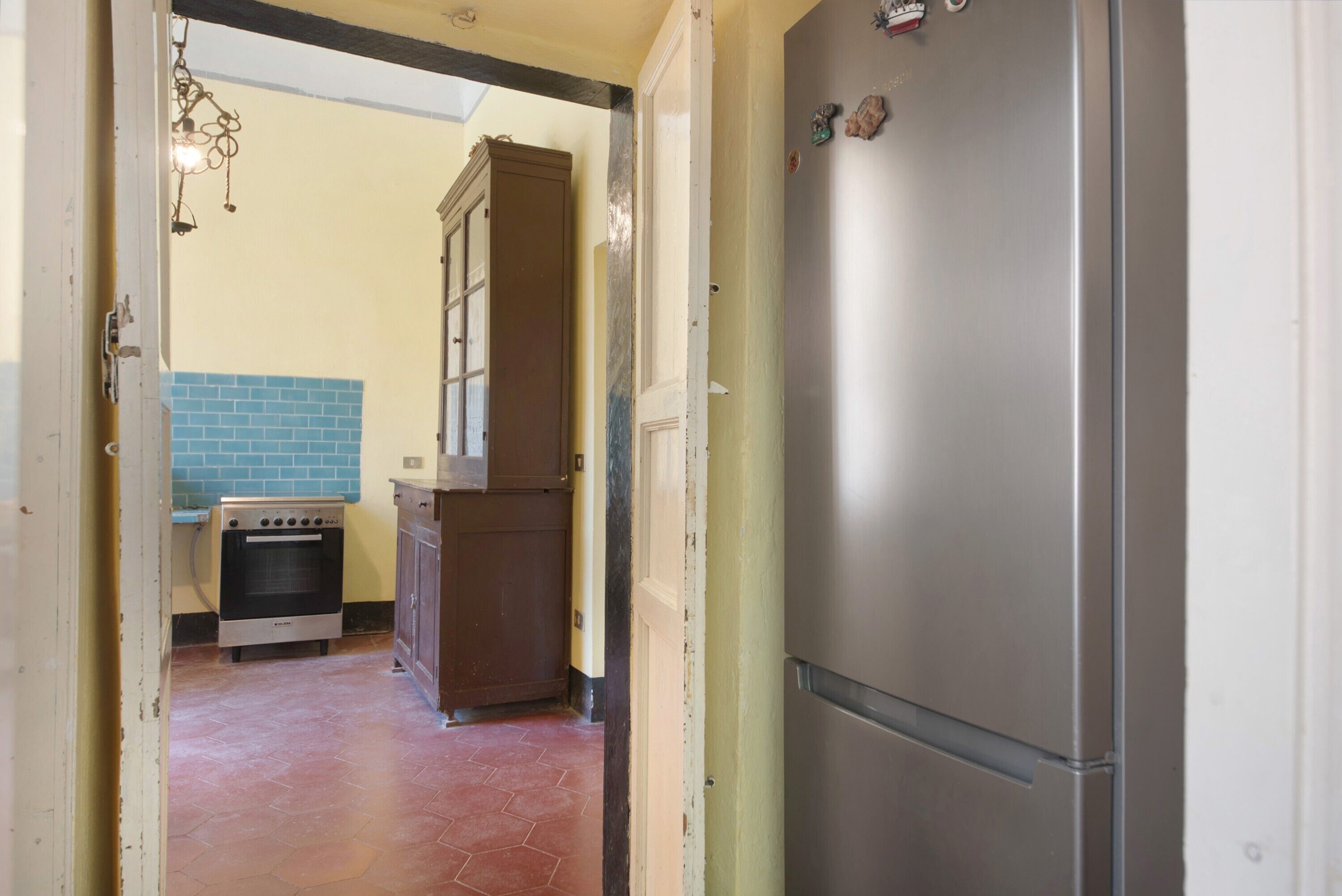 Eine Küche mit Kühlschrank, Backofen und Holzschrank.